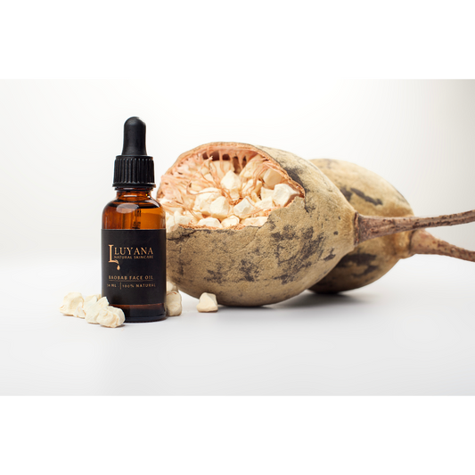 Amber glass bottle with Baobab Oil, next to an open Baobab fuit