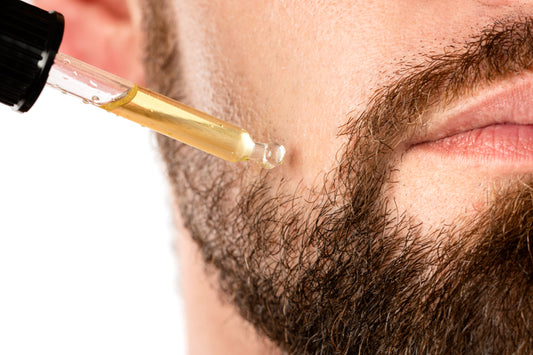 Bearded man applying oil with a pipette