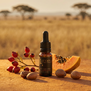 Bottle of Luyana skincare serum with fruits and seeds on a sandy background