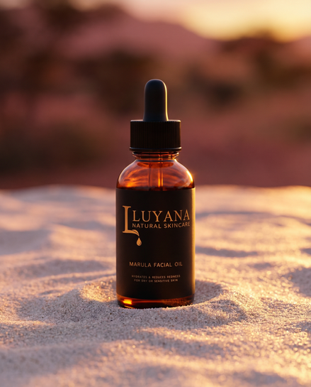 Luyana Skincare Marula Oil in a dropper bottle on sand with sunset background.