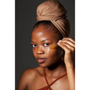 Lifestyle photo of woman dropping oil onto her face